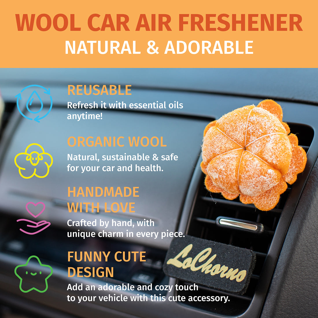 A handmade needle-felted mandarin fruit air freshener is clipped onto a black car air vent. 